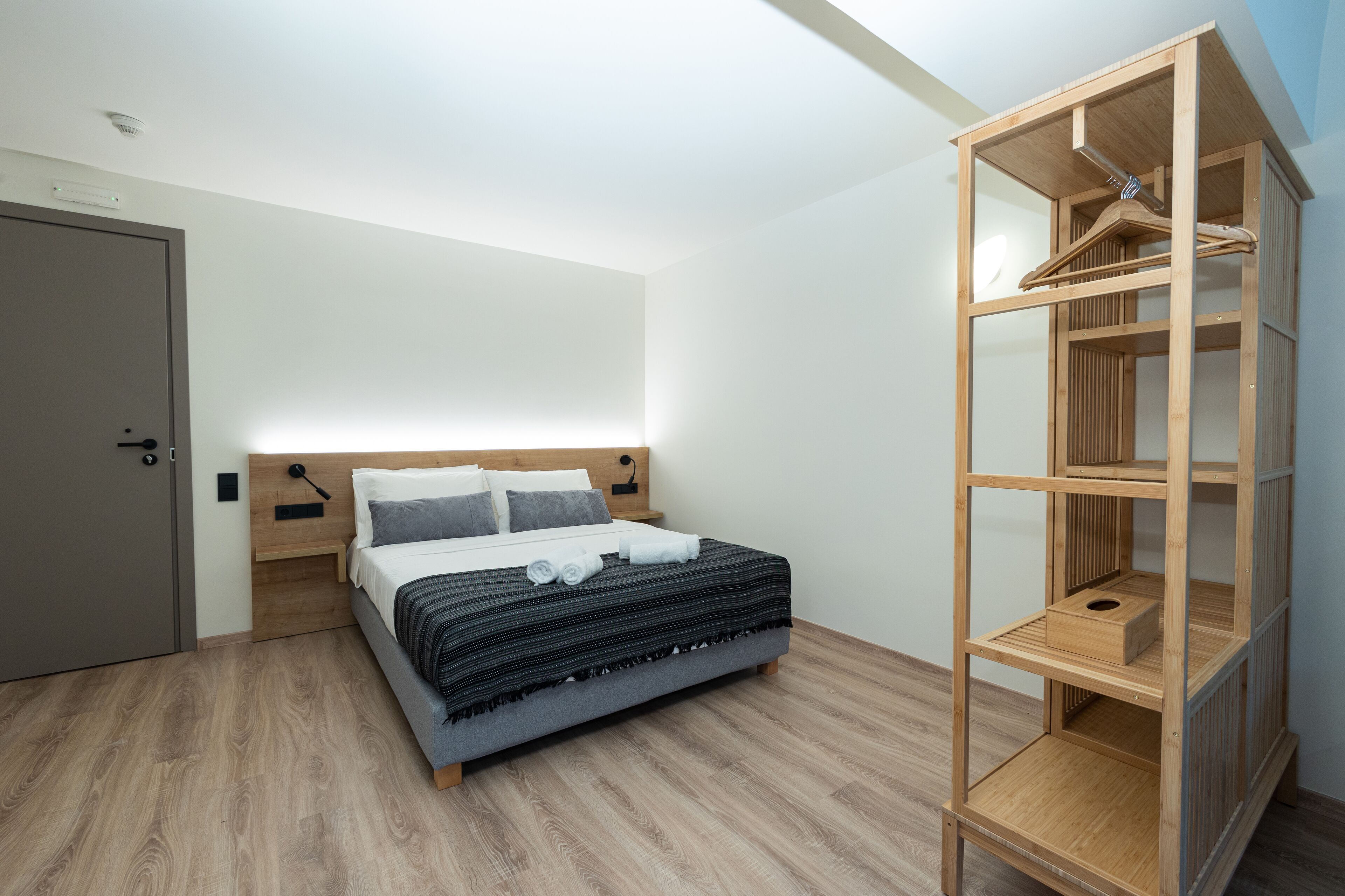 Ein Schlafzimmer mit einem Bett, einem Holzschrank und einer Tür.