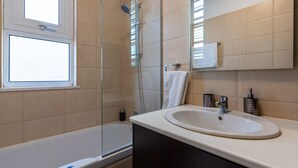 A modern bathroom with a bathtub, shower, and sink. - Harbor 102: Stylish 1-Bedroom Apartment in Larnaca (Cyprus - Larnaca)