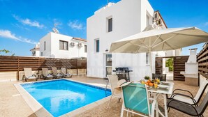 A poolside area with a table and chairs, a barbecue grill, and a white umbrella. - 3BR Villa with Private Pool - Dafni by Premier (Pernera)