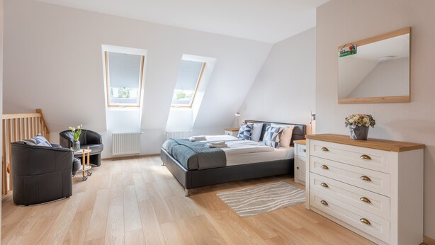 A modern bedroom with a loft bed, a desk, and a chair. - Ferienwohnung am Meer, Urlaub auf der Insel Usedom, Apartment Bianco 49 (Świnoujście)
