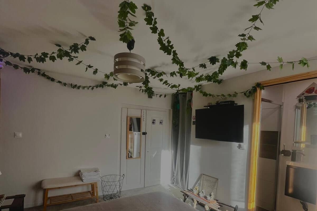 Un dormitorio con cama, un banco, una silla y una televisión.