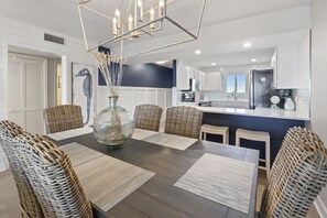 A modern kitchen with white cabinets, a dark countertop, and a built-in refrigerator. - Renovated Sandy Key Penthouse With Upper Level Gulf Views! Treat Yourself! (Perdido Key)