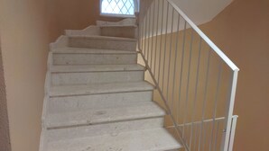 A staircase with white railings and a small window at the top. - RMaison Luxury Suites Olbia  (Olbia)
