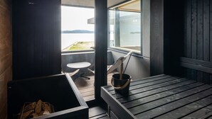 Una terraza de madera con una mesa, sillas, un cubo y una parrilla.
