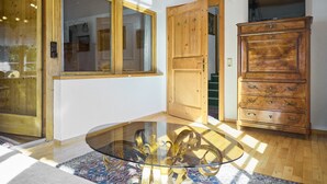 Une pièce avec une table en verre, des meubles en bois et une grande fenêtre.