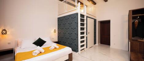 Un dormitorio con cama, escalera blanca, armario y puerta.