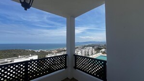 Un balcon avec vue sur la mer et le paysage urbain.