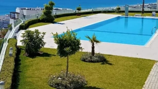 Une piscine avec vue sur la mer et les montagnes.