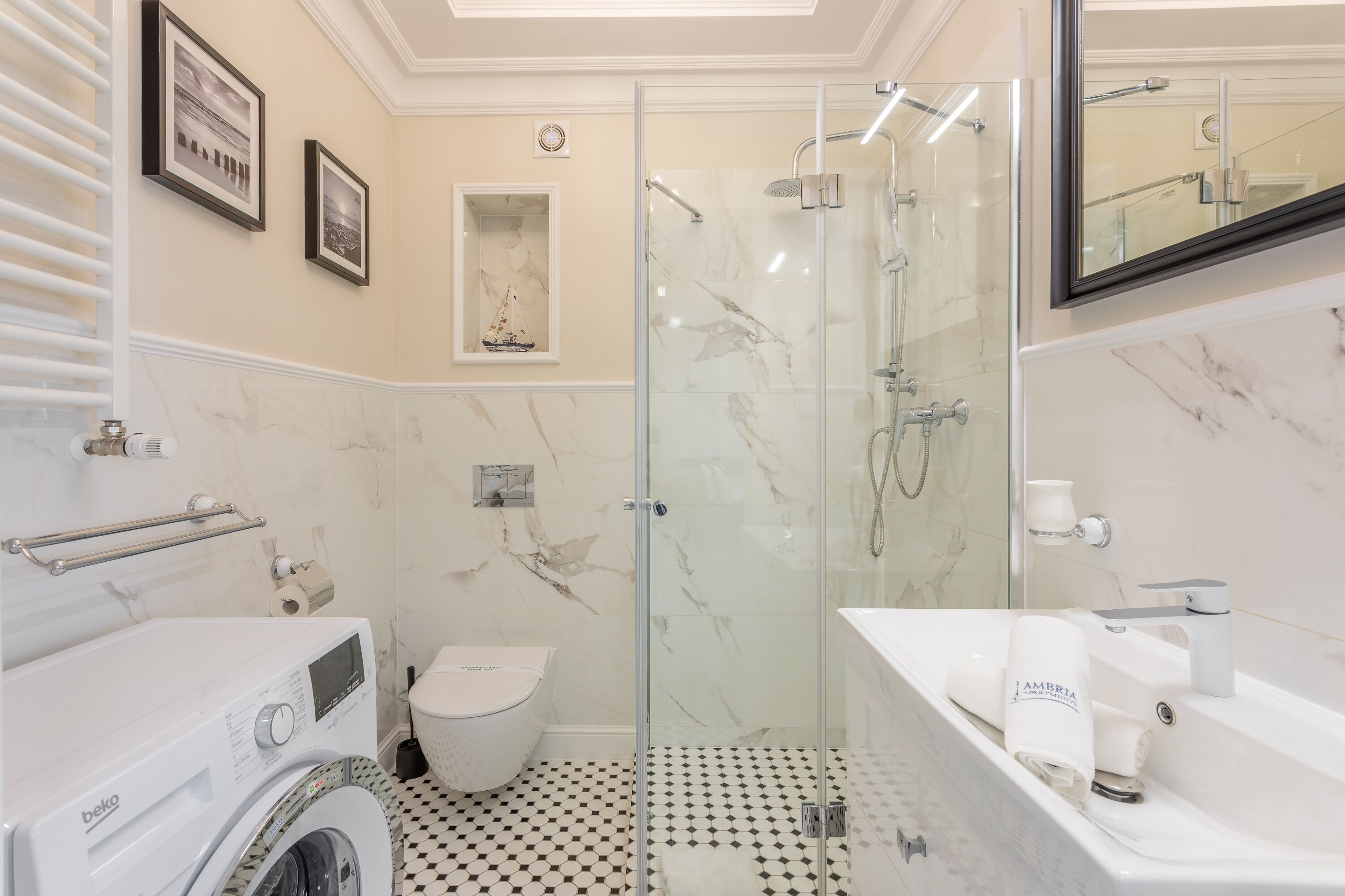 Un baño moderno con ducha de vidrio, inodoro blanco, lavadora y bañera.