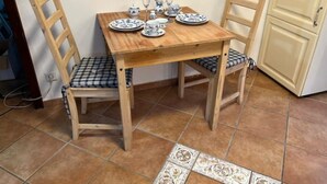A dining table with four chairs, a tiled floor, and a cabinet in the background. - Hummelglück - Holiday apartment with terrace, close to Hamburg (Bendestorf)