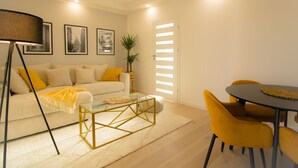 A modern living room with a sofa, coffee table, and yellow chairs. - Luxury Apartment in the heart of Vienna  (Vienna)