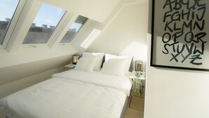 A bedroom with a bed, skylight windows, and a wall-mounted alphabet art piece. - Luxury Apartment in the heart of Vienna  (Vienna)