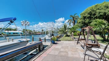 A marina with boats docked, a wooden swing set, and a clear blue sky.