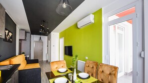 Un espace repas moderne avec une table en verre, des sets de table jaunes et des chaises à revêtement marron.