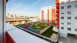 Un immeuble de grande hauteur doté de balcons, d’un jardin sur le toit et d’un espace de jeux pour enfants.