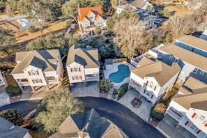 A residential area with multiple houses, including a large house with a swimming pool and a smaller house with a garage.