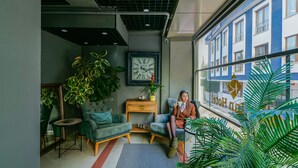 A modern interior with a seating area, a clock, and a view of a building outside. - Rise Inn  (Istanbul)