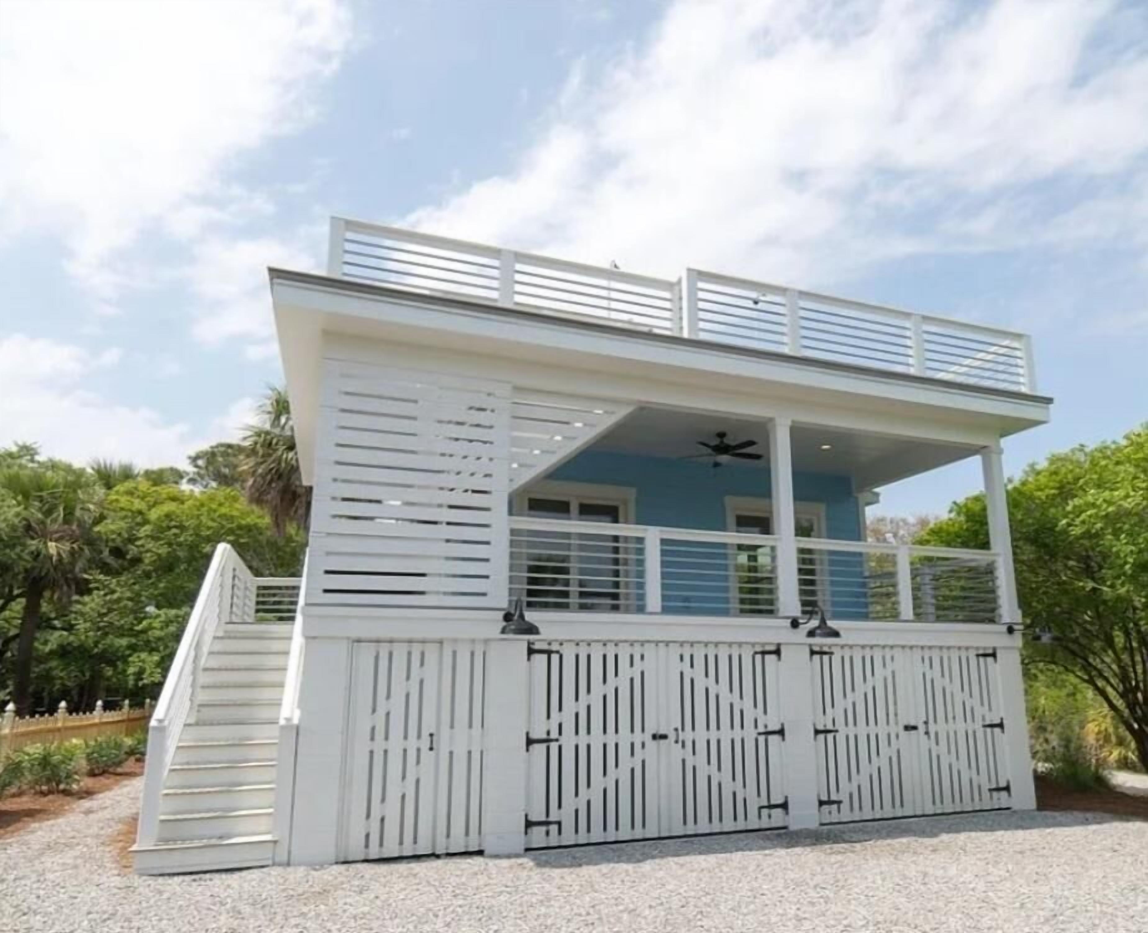 A two-story building with a covered upper deck, a staircase, and a gated entrance.