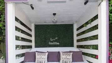 A cozy, enclosed bed area with a green wall and a ceiling light.