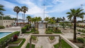 Ein Poolbereich eines Resorts mit Palmen und einem Eingangstor.