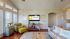 A living room with a television, a yellow armchair, a sofa, and a coffee table. - Absolute Paradise: 3 BR, 2 BA House in Crystal Beach , Sleeps 14 (Bolivar Peninsula)