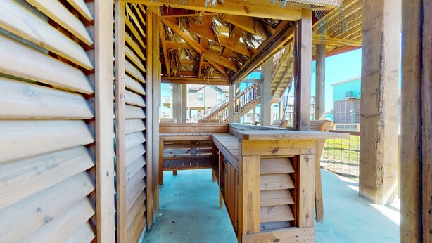 Une structure en bois comprenant un banc, une petite table et un escalier menant à un niveau supérieur.