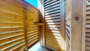 Une structure en bois avec des lattes horizontales, une petite fenêtre et une porte.