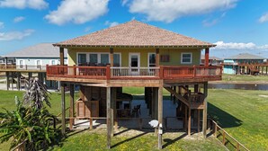 Une construction en bois à deux étages, dotée d’un balcon, d’une terrasse couverte et d’une petite piscine.