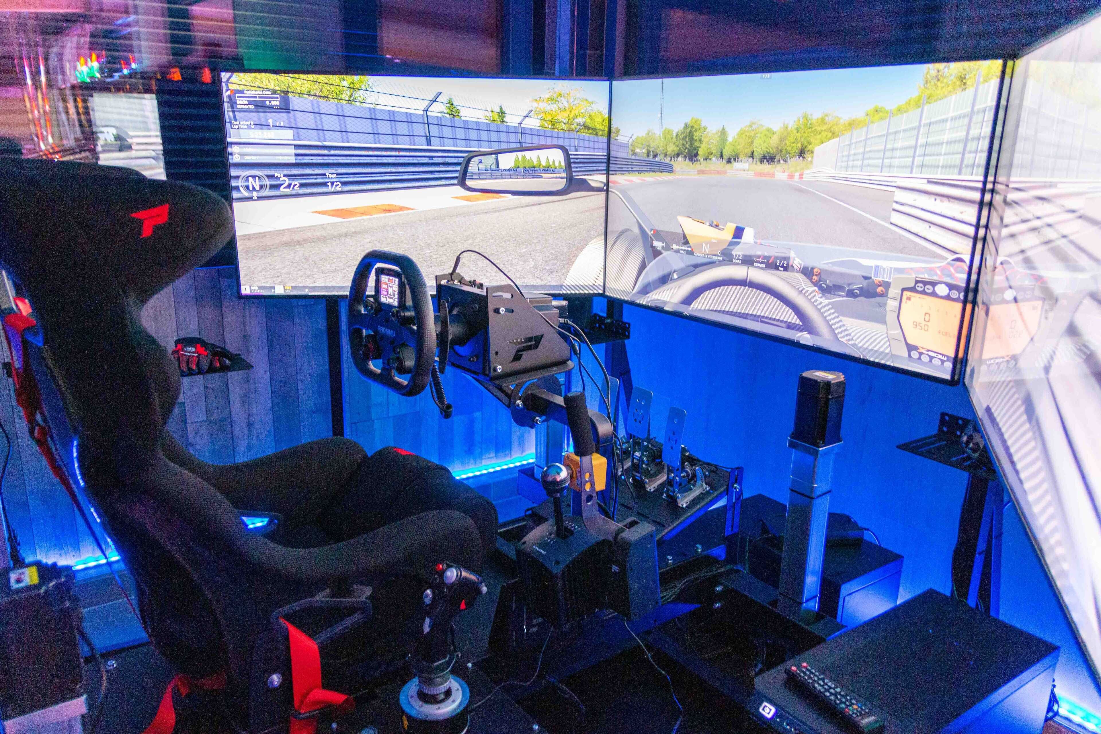 A racing simulator setup with a steering wheel, pedals, and multiple screens displaying a racing track.