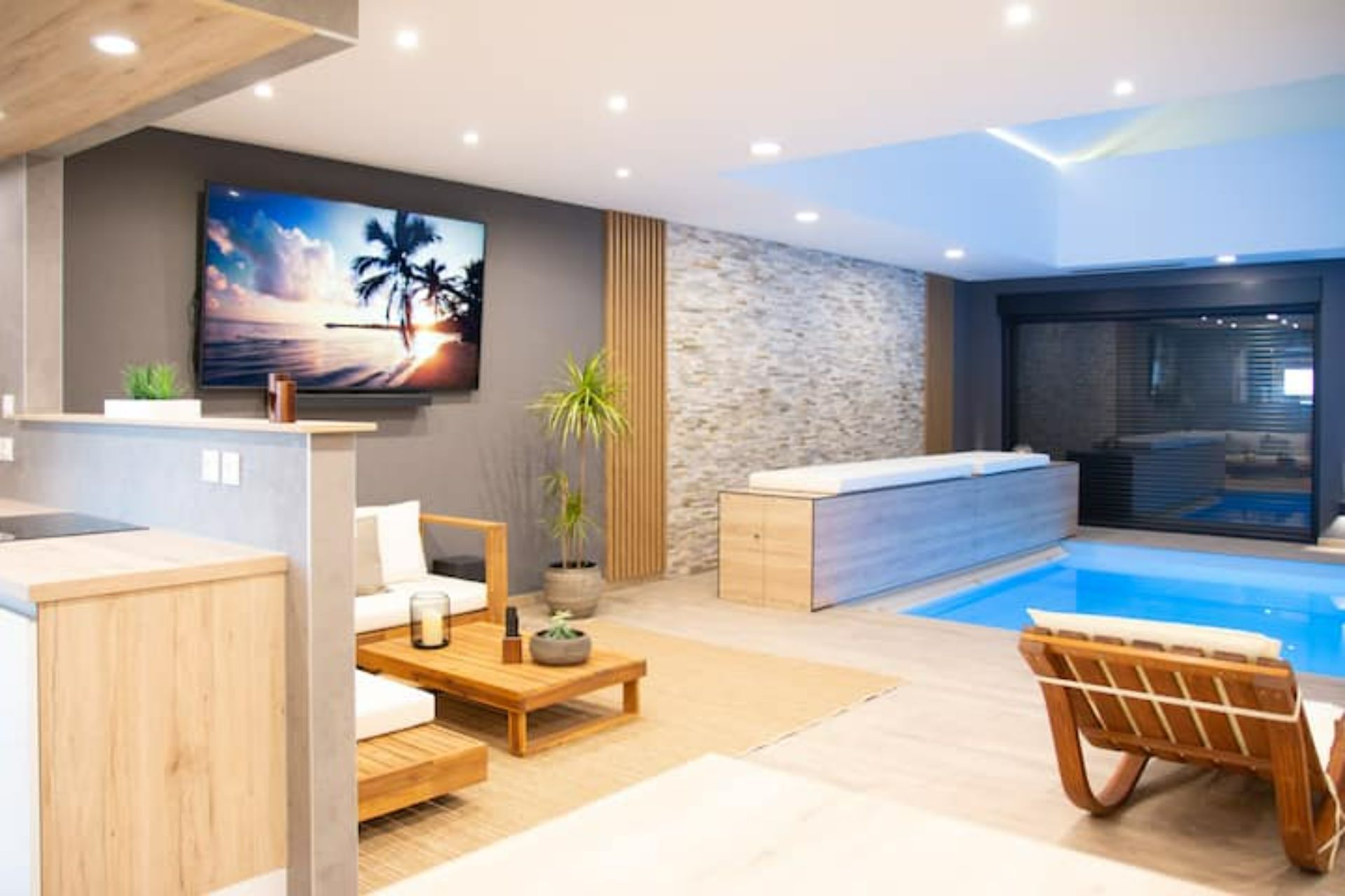 Un salon moderne avec une piscine, un grand téléviseur et un espace dédié au bien-être.