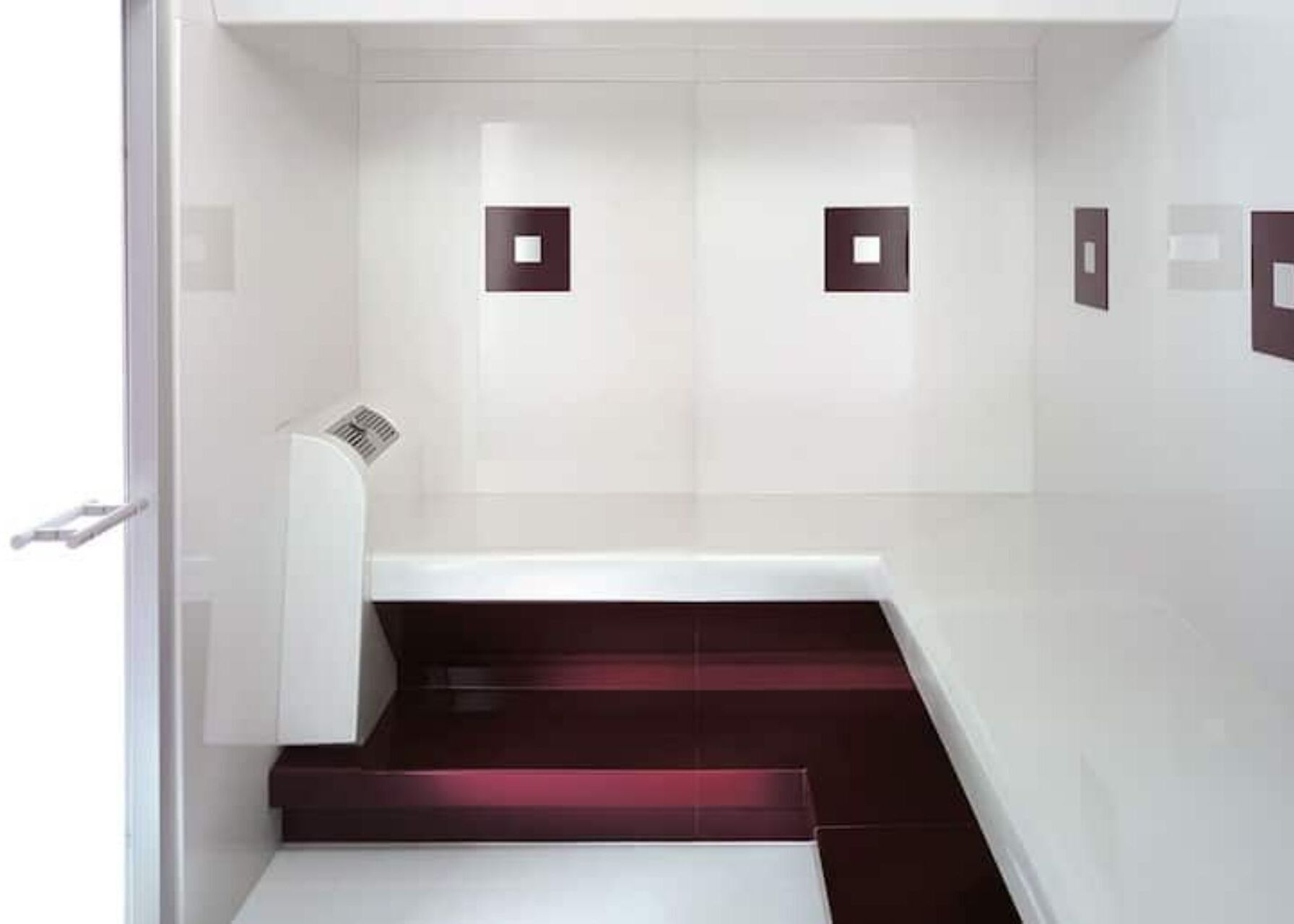 Ein modernes Badezimmer mit weißen Wänden, dunkelroten Stufen und einer weißen Badewanne.