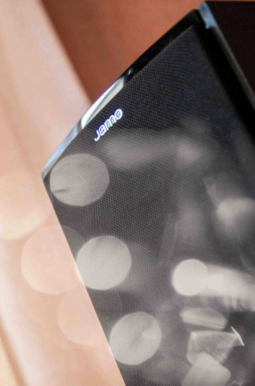 Gros plan d’un smartphone sur lequel on peut voir le nom de la marque, « JAMRO », affiché sur l’écran.