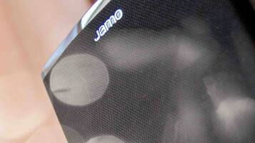 Gros plan d’un smartphone sur lequel on peut voir le nom de la marque, « JAMRO », affiché sur l’écran.