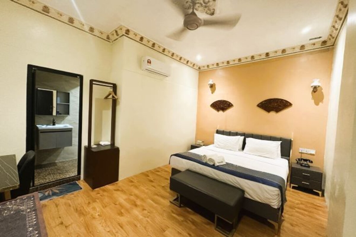 A bedroom with a bed, bedside tables, a mirror, and a ceiling fan.
