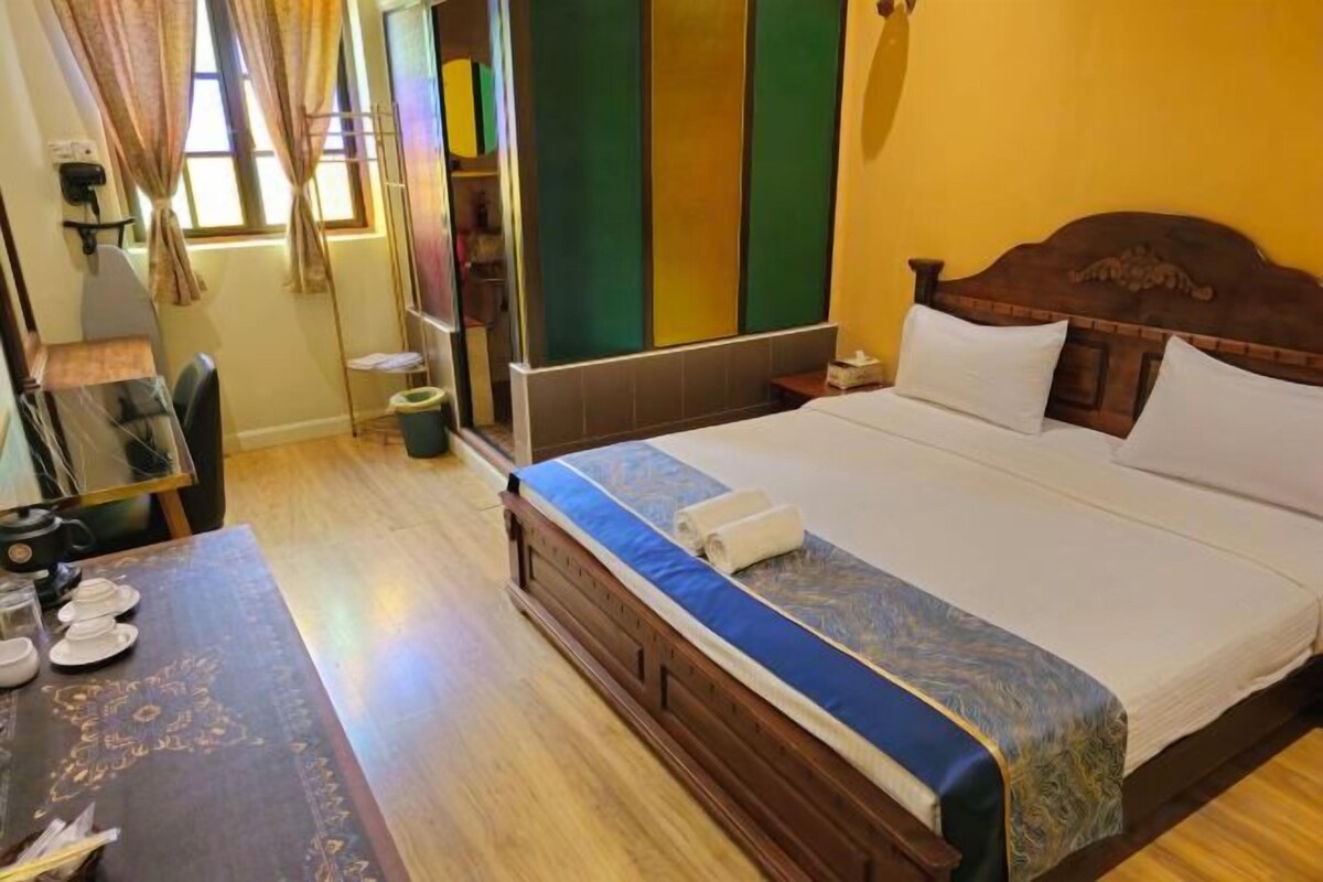 A hotel room with a wooden bed, a desk, and a chair.