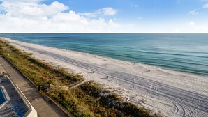 A beach with a wooden boardwalk, a pool, and a clear view of the ocean. - Gulf-Front at Aquavista w/ Pool, Hot Tub & Sunset Views (Panama City Beach)