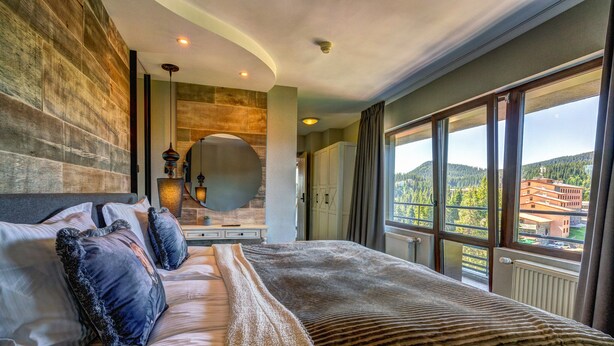 Een ruime slaapkamer met een groot bed, uitzicht op de omgeving en een modern design.