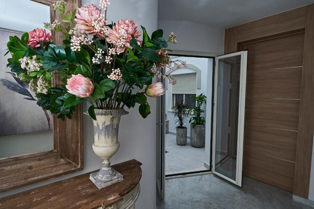 A room with a wooden floor, a mirror, and a large window.