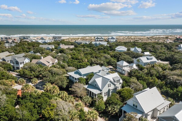 A coastal residential area with houses surrounded by dense greenery and a view of the ocean. - "The Beach House" - BHI and Shoals, Pet Friendly, Southern Living (Bald Head Island)