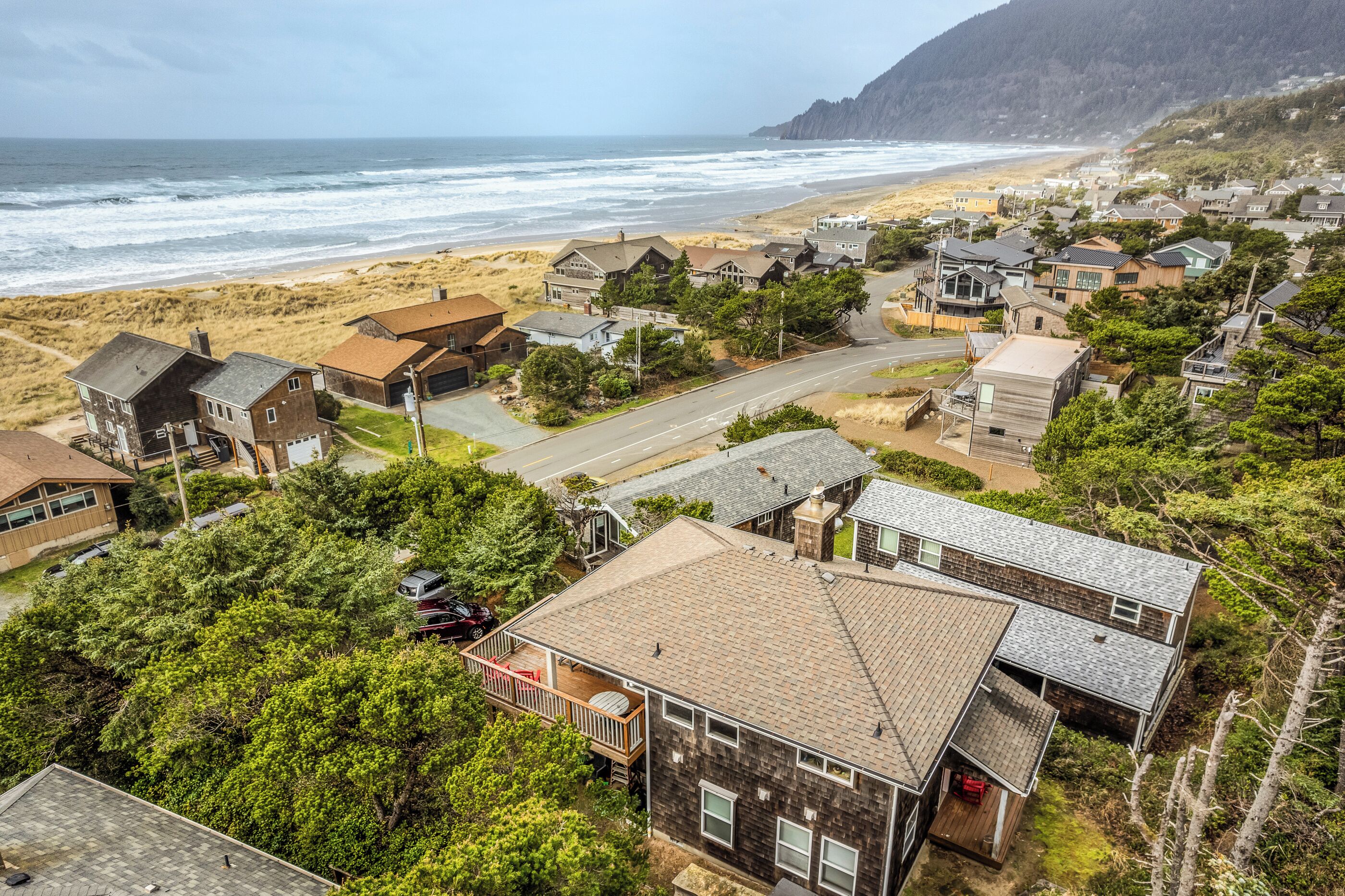 A coastal residential area with houses, a beach, and a road.
