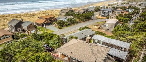 A coastal residential area with houses, a beach, and a road.