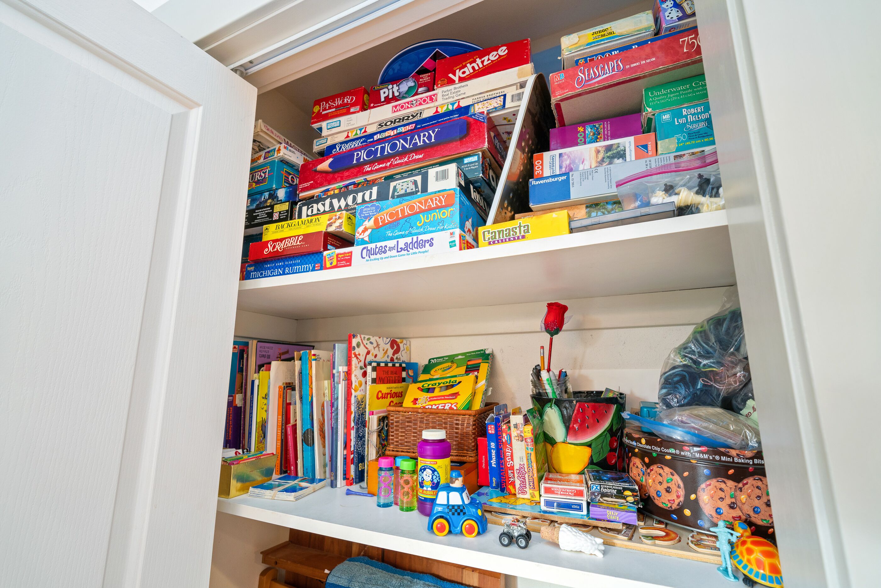 A shelf filled with board games and puzzles.