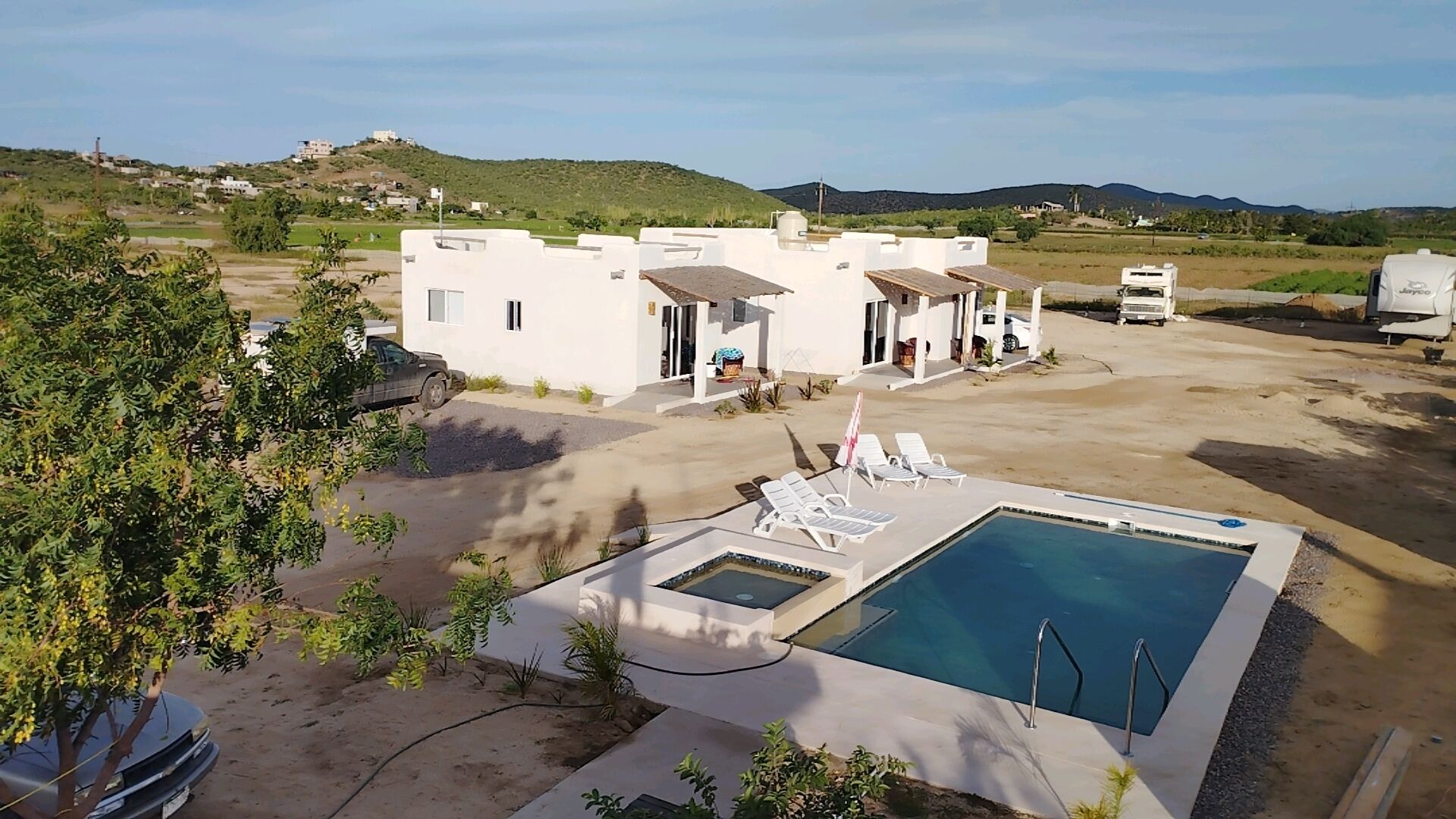 Una villa moderna con piscina, mobiliario exterior y vistas al paisaje circundante.