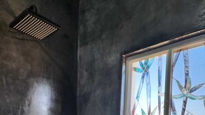 A bathroom with a shower, a window with bamboo decoration, and a wall-mounted faucet. - Vista Sierra Laguna (El Pescadero)