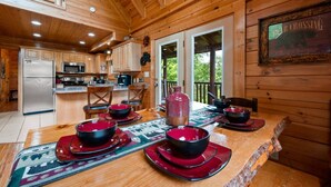 A wooden cabin interior with a kitchen, dining area, and a sign reading "Fear Crossing". - Stunning 5BD Cabin! HOT TUB +Close to Town +VIEWS! (Sevierville)