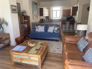 A living room with a sofa, coffee table, and leather couch.