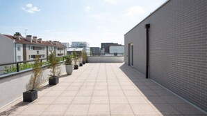 A rooftop terrace with potted plants, a tiled floor, and a view of surrounding buildings. - Beautiful 3 bedroom apartment 20 min from Paris

 (Vigneux-sur-Seine)