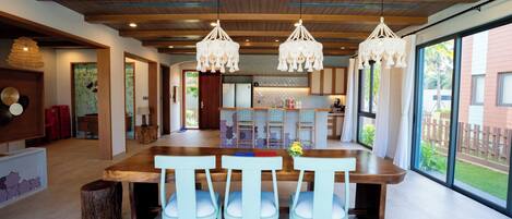 A spacious kitchen with a large island, wooden ceiling beams, and pendant lights.