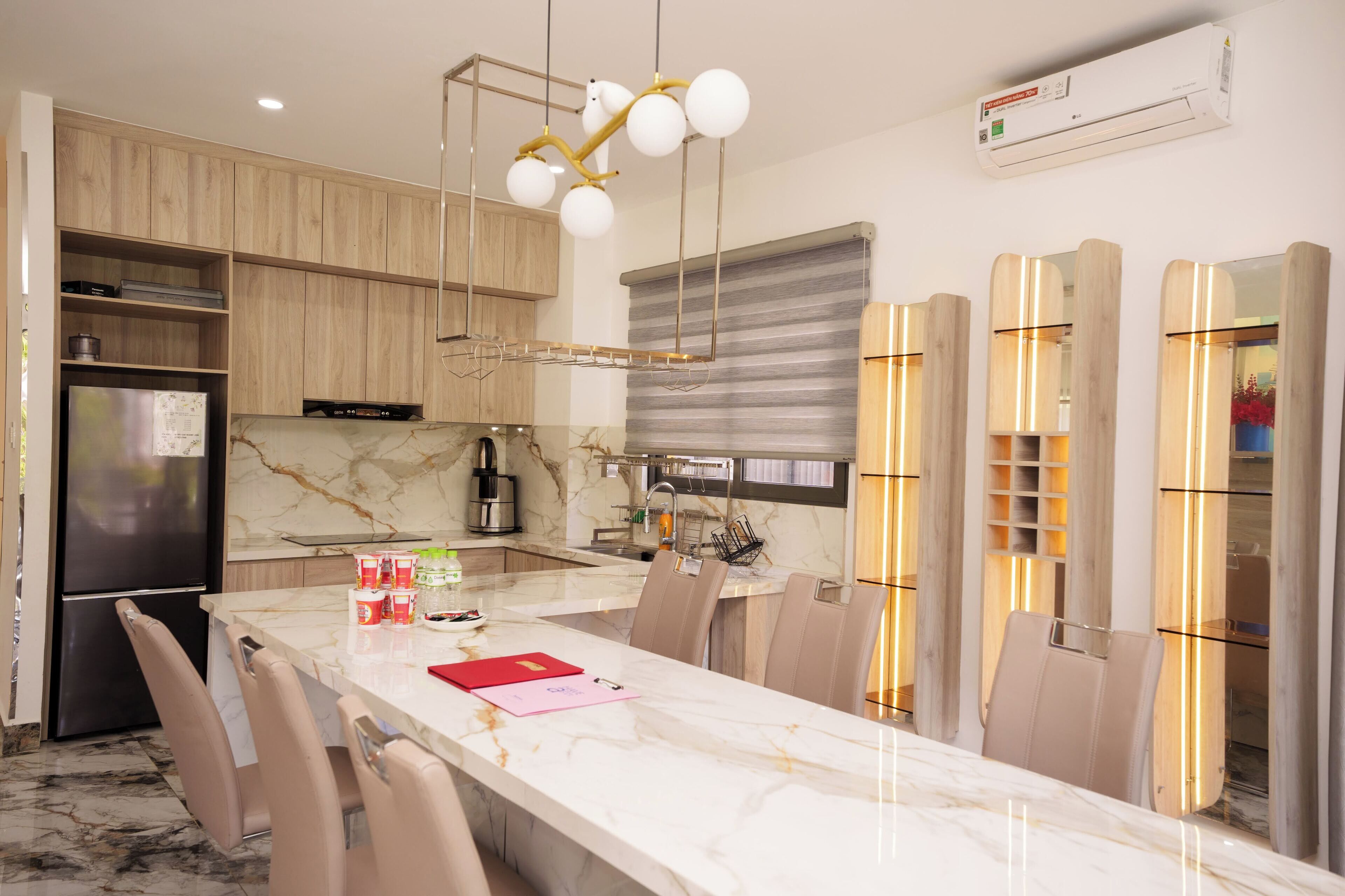 A modern kitchen with a marble countertop, built-in appliances, and a central island with seating.