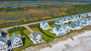 Una zona residenziale costiera con diverse case caratterizzate da ampi portici e vista sul mare.
